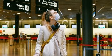 Pasajero con mascarilla en el aeropuerto