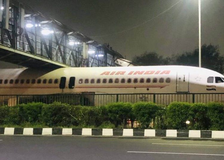 Un viejo avión de Air India, atrapado bajo un puente en una autopista cerca del aeropuerto de Delhi