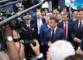 Macron escucha al CEO de Dassault Aviation, Eric Trappier, junto a una réplica de un avión de combate Rafale, durante su visita al Salón.