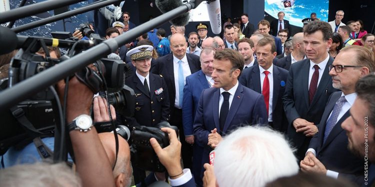 Macron escucha al CEO de Dassault Aviation, Eric Trappier, junto a una réplica de un avión de combate Rafale, durante su visita al Salón.
